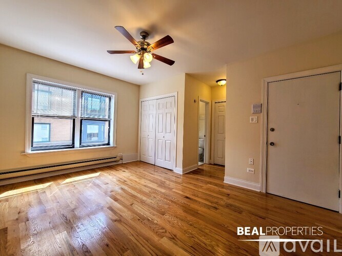 A room with a ceiling fan and wooden flooring.