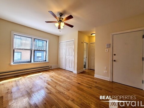 A room with a ceiling fan and wooden flooring.