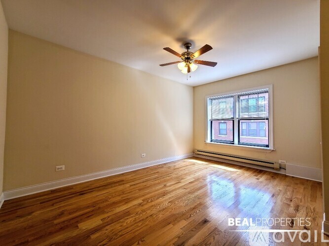 A room with a ceiling fan and wooden flooring.