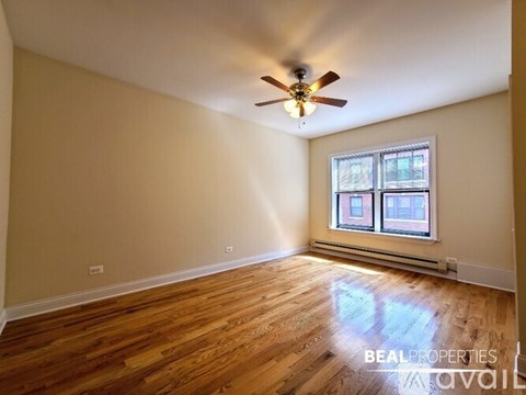 A room with a ceiling fan and wooden flooring.