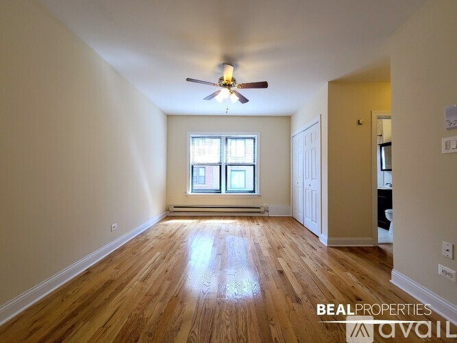 A room with wooden floors and a ceiling fan.