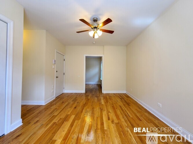 A room with wooden floors and a ceiling fan.