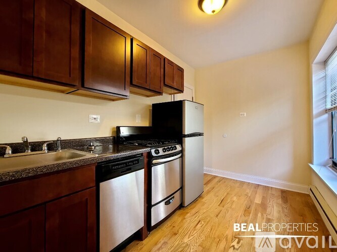 A kitchen with dark wood cabinets and stainless steel appliances.
