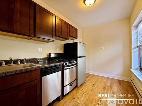 A kitchen with dark wood cabinets and stainless steel appliances.