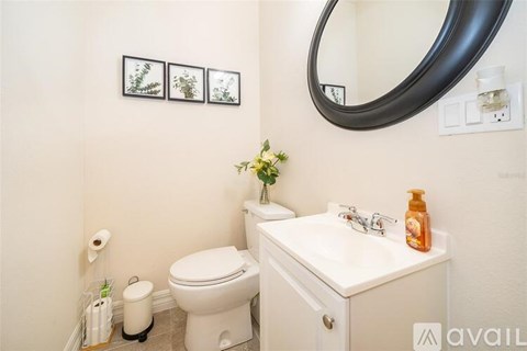 A bathroom with a toilet, sink, and mirror.