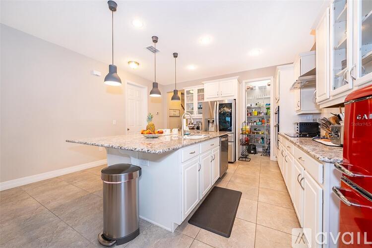 A kitchen with white cabinets and a marble countertop.