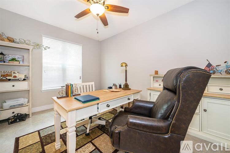 A room with a brown leather chair and a wooden desk.