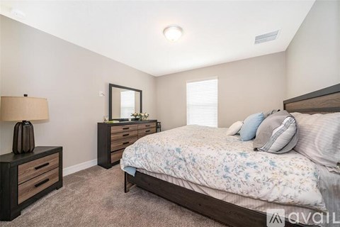 A bedroom with a bed, nightstand, and lamp.