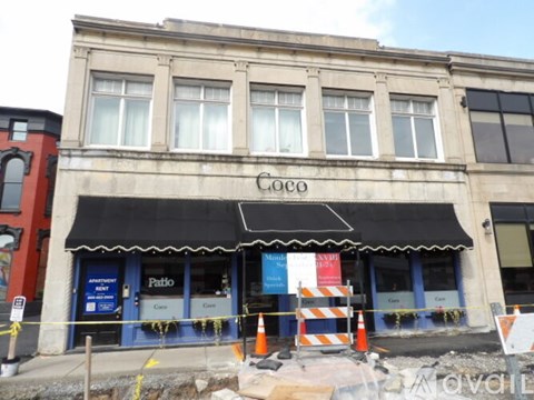 A building with a black awning and the word "Coco" on it.