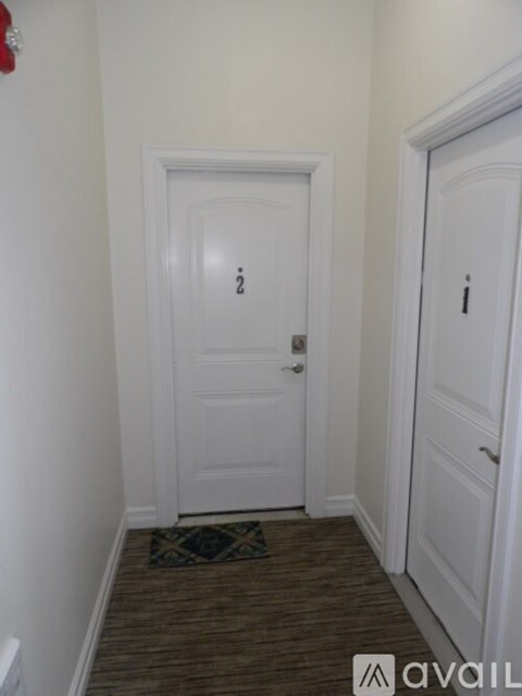 A hallway with a door on the left and a door on the right.