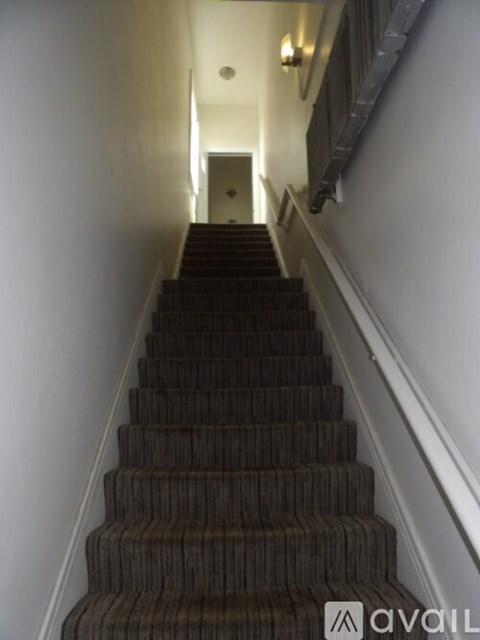 A staircase with a carpeted runner and wooden balusters.