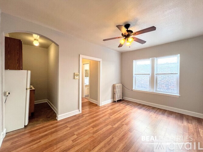 A room with a ceiling fan and wooden flooring.