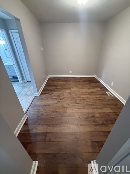 A room with wooden flooring and white walls.