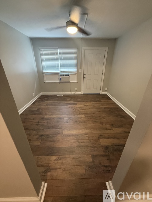 A room with wooden flooring and a ceiling fan.