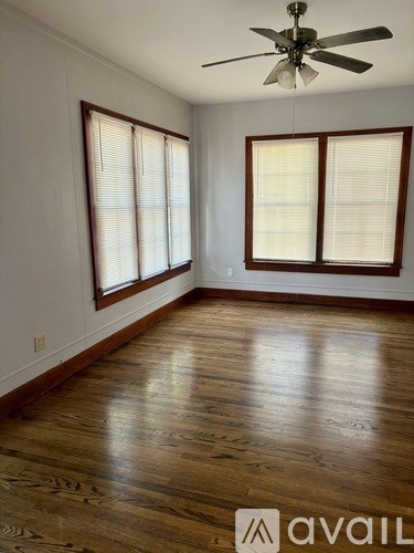 A room with wooden floors and a ceiling fan.