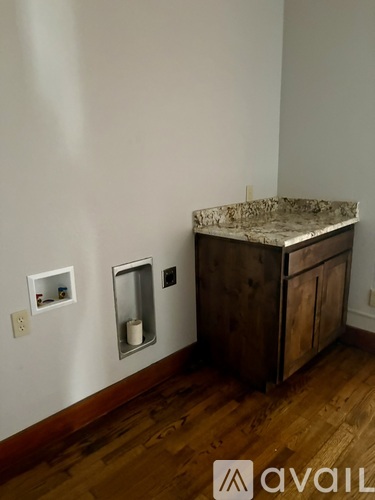A kitchen counter with a marble top and wooden cabinets.