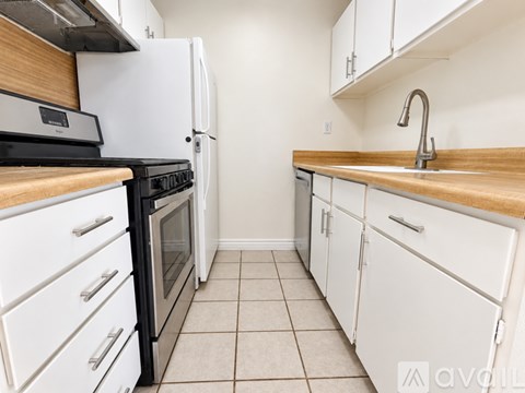 A kitchen with white appliances and wooden countertops.