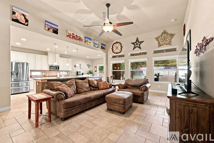 A living room with a brown couch and a ceiling fan.