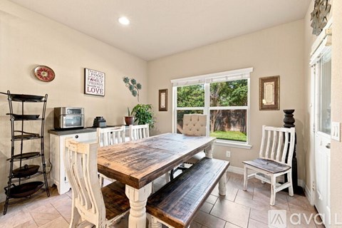 A dining room with a wooden table and chairs.