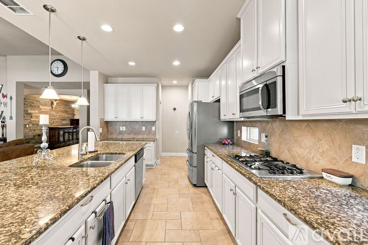 A kitchen with granite countertops and white cabinets.