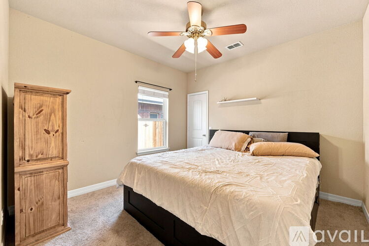 A bedroom with a bed, dresser, and window.