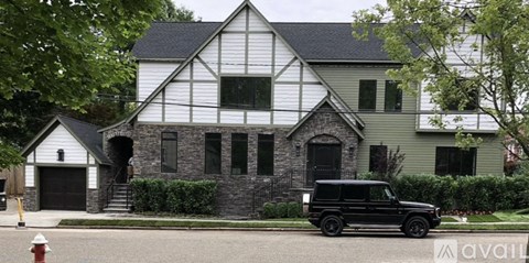 A black car is parked in front of a house.