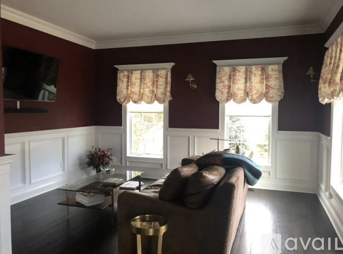 A living room with a brown couch and a glass coffee table.