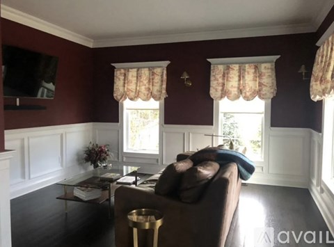 A living room with a brown couch and a glass coffee table.