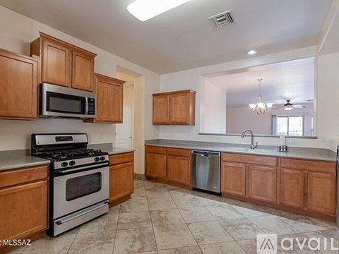 A kitchen with wooden cabinets and a stainless steel dishwasher.