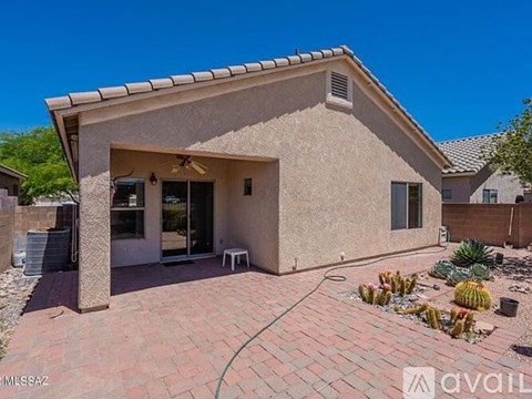A house with a beige stucco exterior and a red brick patio.