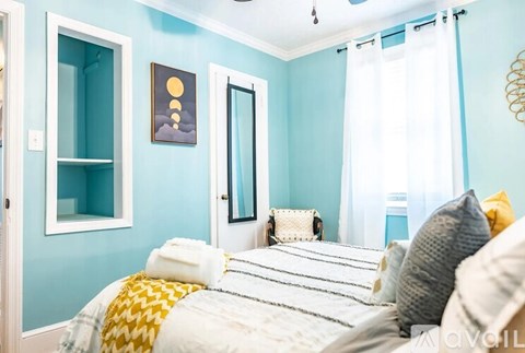 A bedroom with a bed and a chair.