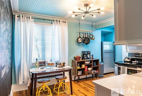 A kitchen with a table and chairs in front of a window.