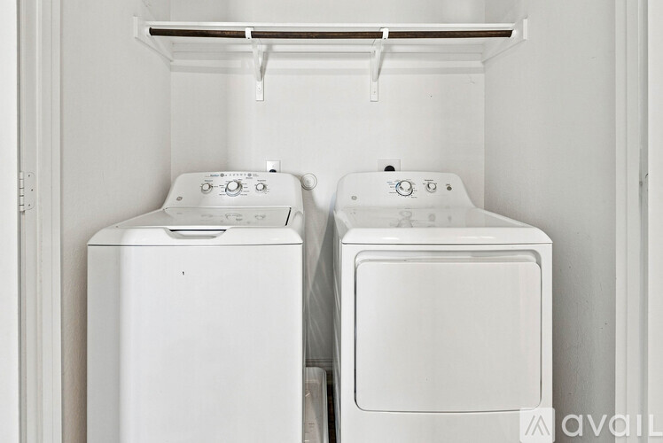 Two white front loading washing machines in a laundry room.