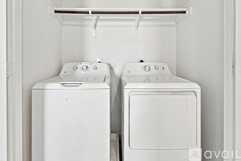 Two white front loading washing machines in a laundry room.