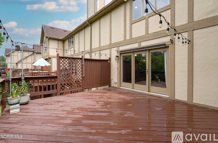A wooden deck with a lattice fence and a patio umbrella.