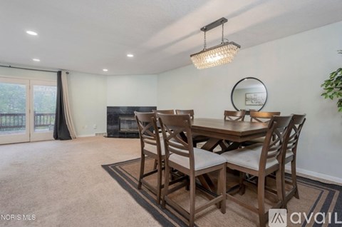 A dining room with a wooden table and chairs.