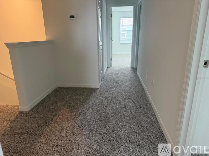A long hallway with a carpeted floor and white walls.