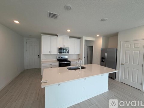 A kitchen with white cabinets and appliances is available for rent.