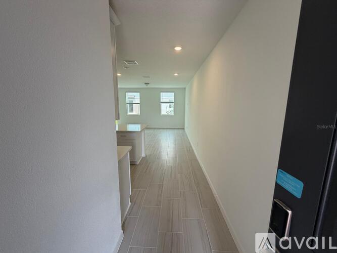 A long hallway with a black door on the right.