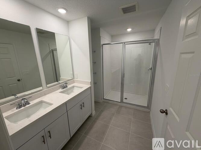 A bathroom with a sink, mirror, and shower.