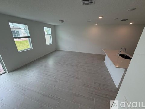 A spacious room with a large window and a tiled floor.
