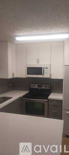 A kitchen with white cabinets and a black stove top oven.