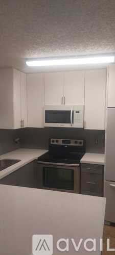 A kitchen with white cabinets and a black stove top oven.