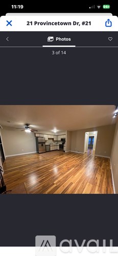 A room with wooden flooring and a white wall.