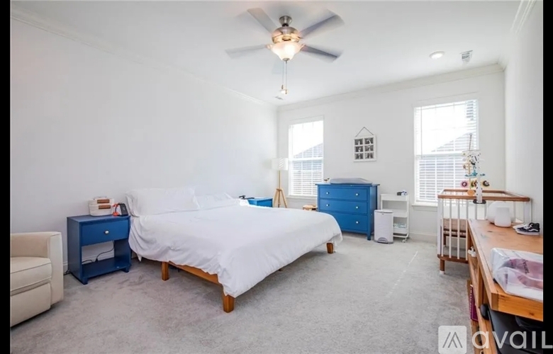 A bedroom with a white bed and blue nightstand.