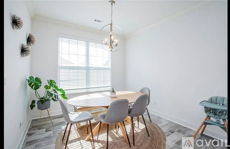 A dining room with a round table and chairs.