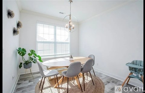 A dining room with a round table and chairs.