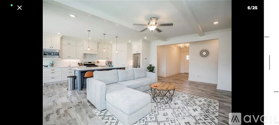 A modern kitchen with a dining area and a living room.