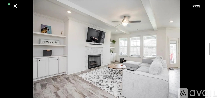 A modern living room with a fireplace and a television mounted on the wall.