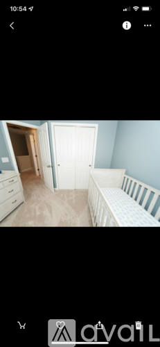 A room with a white door and a white bed.
